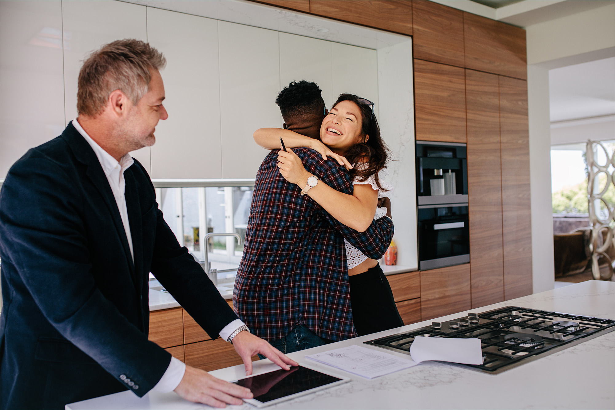 A couple hugging after signing their house contract